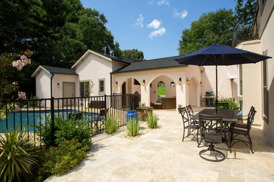 Large tuscan backyard stone patio photo in DC Metro with a roof extension