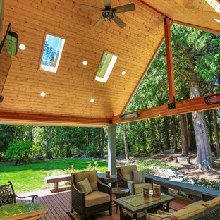 Esempio di un grande patio o portico stile americano dietro casa con pedane e un tetto a sbalzo