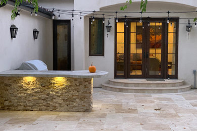 Ejemplo de patio mediterráneo de tamaño medio sin cubierta en patio trasero con cocina exterior y adoquines de piedra natural