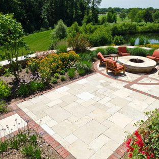 Foto di un patio o portico stile americano di medie dimensioni e dietro casa con un focolare, pavimentazioni in pietra naturale e nessuna copertura