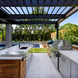 Idee per un patio o portico design di medie dimensioni e dietro casa con un focolare e un tetto a sbalzo