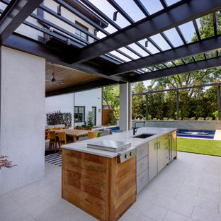 Idee per un patio o portico minimal di medie dimensioni e dietro casa con un focolare e un tetto a sbalzo