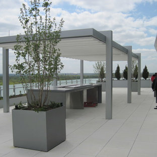 Patio - large modern courtyard tile patio idea in DC Metro with a pergola