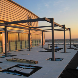 Large minimalist courtyard tile patio photo in DC Metro with a pergola