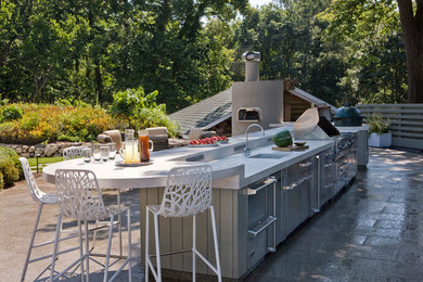 Modelo de patio clásico renovado sin cubierta en patio lateral con cocina exterior y adoquines de piedra natural