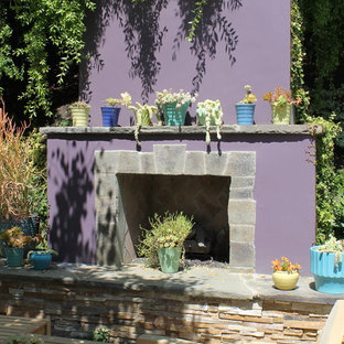 Idee per un patio o portico bohémian di medie dimensioni e dietro casa con un focolare, lastre di cemento e nessuna copertura