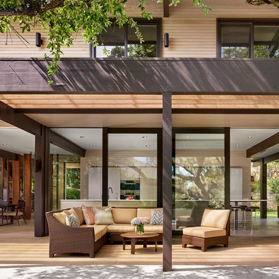 Example of a large trendy backyard patio fountain design in Austin with decking and a pergola