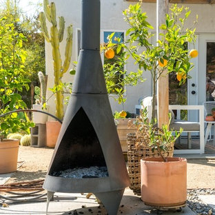 Ispirazione per un patio o portico classico di medie dimensioni e dietro casa con pavimentazioni in cemento e un caminetto