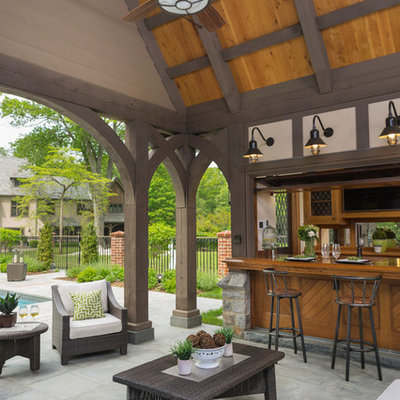 Example of a large classic backyard tile patio kitchen design in New York with a roof extension