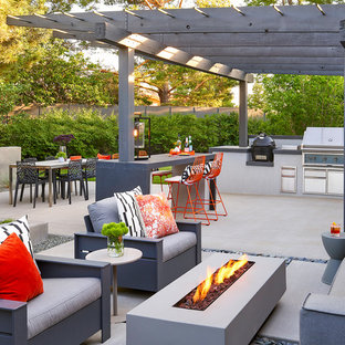 Mid-century modern backyard concrete patio kitchen photo in Denver with a pergola