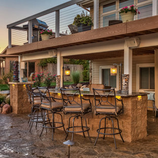 Foto di un grande patio o portico tradizionale dietro casa con cemento stampato e un tetto a sbalzo