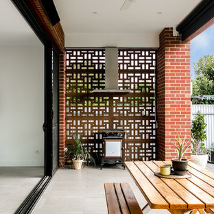 Photo of a contemporary backyard patio in Adelaide with an outdoor kitchen, concrete pavers and a roof extension.