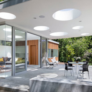 Ejemplo de patio moderno, en anexo de casas, con losas de hormigón