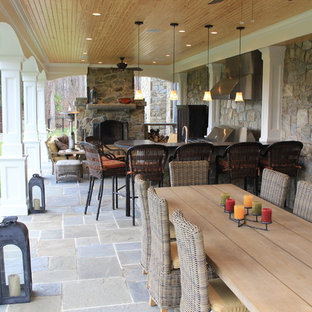 Ispirazione per un patio o portico stile americano di medie dimensioni e dietro casa con piastrelle e un tetto a sbalzo