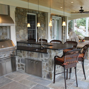 Esempio di un patio o portico stile americano di medie dimensioni e dietro casa con piastrelle e un tetto a sbalzo