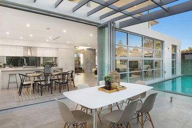 Design ideas for a medium sized contemporary back patio in Sydney with an outdoor kitchen, tiled flooring and a pergola.