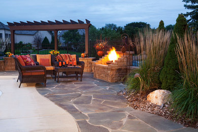 Patio - mid-sized traditional backyard stone patio idea with a fire pit and a pergola