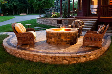Mid-sized elegant backyard brick patio photo with a roof extension