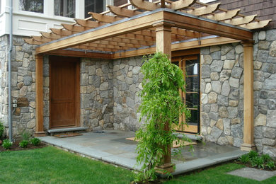 Inspiration for a large contemporary backyard stone patio remodel in New York with a fire pit and a pergola