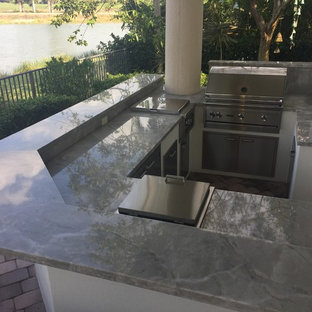 Foto di un patio o portico tropicale dietro casa con pavimentazioni in mattoni e un tetto a sbalzo
