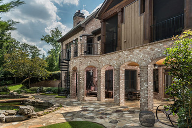 Diseño de patio tradicional renovado grande sin cubierta en patio trasero con adoquines de piedra natural