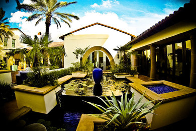 Patio fountain - large mediterranean courtyard brick patio fountain idea in Tampa with no cover