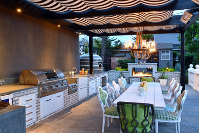 Minimalist backyard stone patio kitchen photo in San Diego with a pergola