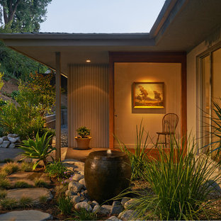 Foto di un patio o portico stile americano di medie dimensioni e dietro casa con fontane, un tetto a sbalzo e pavimentazioni in pietra naturale