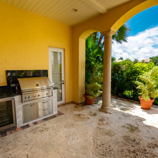 Idee per un patio o portico mediterraneo dietro casa con pavimentazioni in mattoni e un tetto a sbalzo