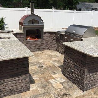 Esempio di un patio o portico design di medie dimensioni e dietro casa con un focolare, graniglia di granito e nessuna copertura