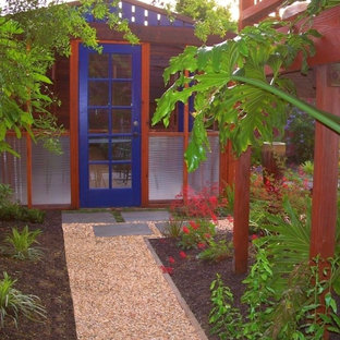 Ispirazione per un patio o portico boho chic di medie dimensioni e dietro casa con pavimentazioni in cemento e una pergola