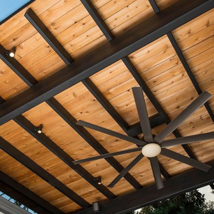Ispirazione per un grande patio o portico minimalista dietro casa con un focolare, pavimentazioni in cemento e un gazebo o capanno