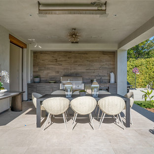 Ispirazione per un grande patio o portico design dietro casa con pavimentazioni in pietra naturale e un tetto a sbalzo