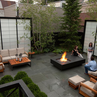 Esempio di un piccolo patio o portico moderno dietro casa con un focolare, piastrelle e nessuna copertura