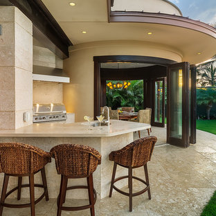 Foto di un grande patio o portico tropicale dietro casa con un tetto a sbalzo e piastrelle