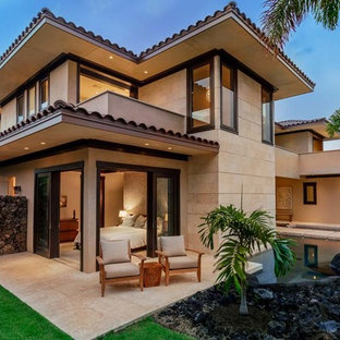 Esempio di un grande patio o portico design davanti casa con piastrelle e un tetto a sbalzo