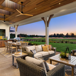 Example of a huge country backyard concrete patio kitchen design in Portland with a roof extension