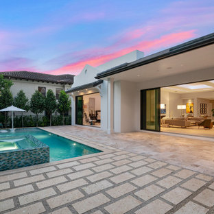 Foto di un patio o portico classico di medie dimensioni e dietro casa con fontane, pavimentazioni in pietra naturale e un tetto a sbalzo