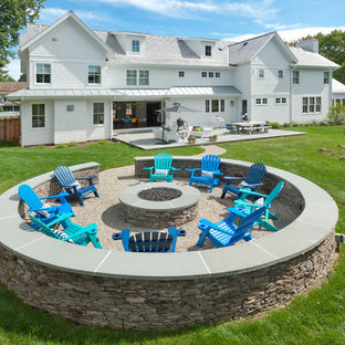 Esempio di un grande patio o portico country dietro casa con un focolare e una pergola