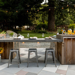 Idee per un patio o portico country dietro casa con pavimentazioni in pietra naturale e nessuna copertura