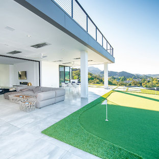 Esempio di un ampio patio o portico minimal dietro casa con piastrelle e un tetto a sbalzo