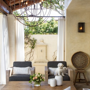 Foto di un grande patio o portico tradizionale dietro casa con fontane, graniglia di granito e un tetto a sbalzo