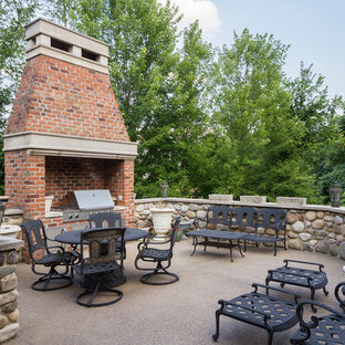 Immagine di un grande patio o portico tradizionale dietro casa con un caminetto, graniglia di granito e nessuna copertura
