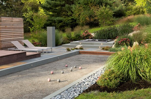 Example of a large minimalist backyard stone patio design in Boston