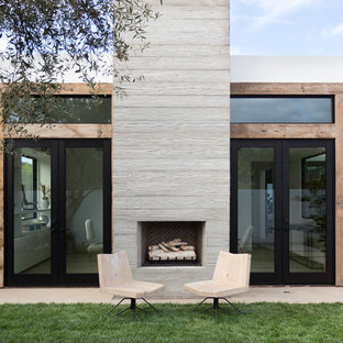 Modelo de patio moderno, sin cubierta, en patio trasero, con adoquines de hormigón y chimenea