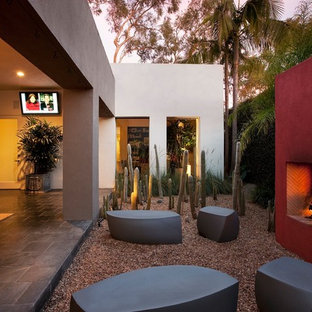 Esempio di un patio o portico contemporaneo in cortile e di medie dimensioni con ghiaia, un focolare e un tetto a sbalzo
