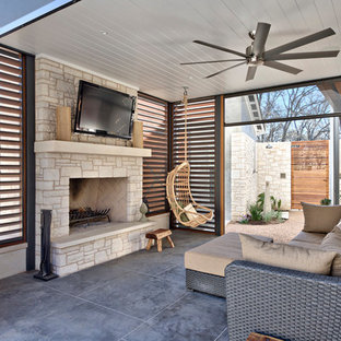 Idee per un ampio patio o portico country con un tetto a sbalzo e un caminetto