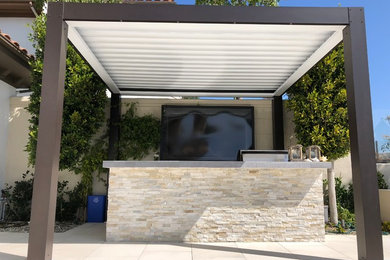 Photo of a medium sized contemporary back patio in Orange County with an outdoor kitchen, tiled flooring and a gazebo.