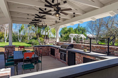 Example of a huge cottage backyard concrete patio kitchen design in San Luis Obispo with a roof extension