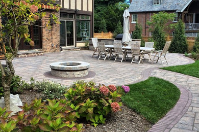 Example of a mid-sized arts and crafts backyard concrete paver patio design in New York with a fire pit and no cover